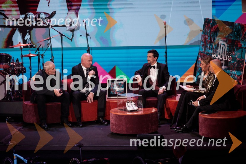  ... ;  Bogdan  Fink , direktor kolesarskega kluba Adria mobil;  Primož Roglič, kolesar;  ... ;  ... Primož Roglič predal naziv botra, dobrodelna prireditev Olimpijskega komiteja Slovenije