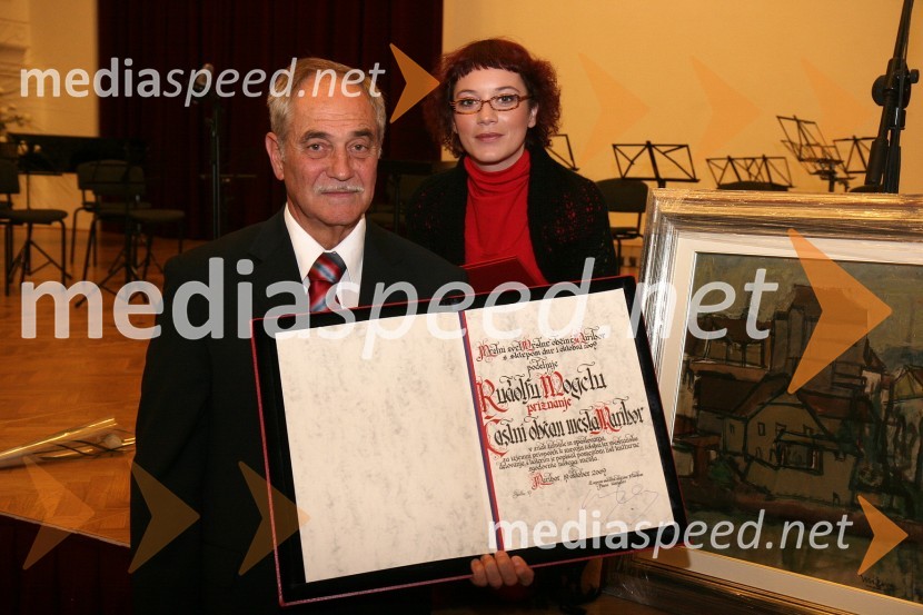 Rudi Moge, nekdanji poslanec DZ in predsednik sveta SNG Maribor ter prejemnik priznanja častni občan in Simona Kopinšek, voditeljica prireditvePodelitev priznanj Mestne občine Maribor za leto 2009 in razglasitev častnega občana