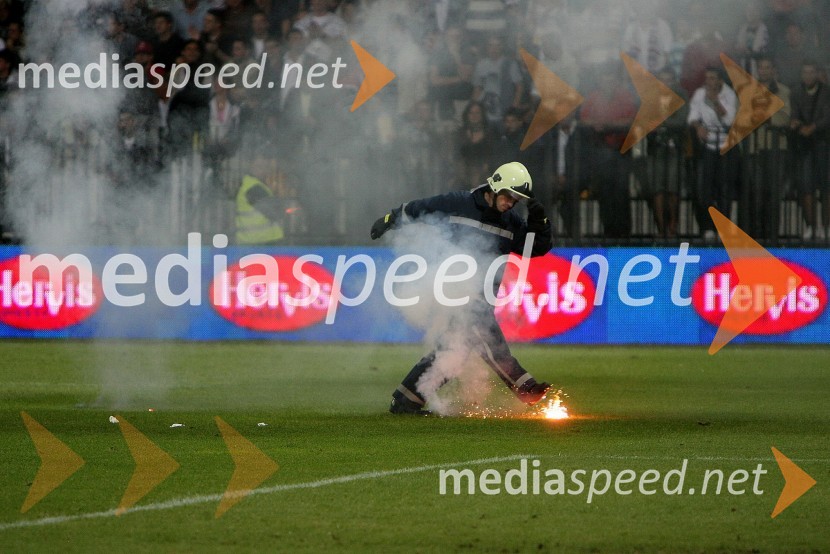 Gasilec igra nogomet z navijaško bakloSlovenija : Hrvaška, nogomet, prijateljska tekma, zakulisje