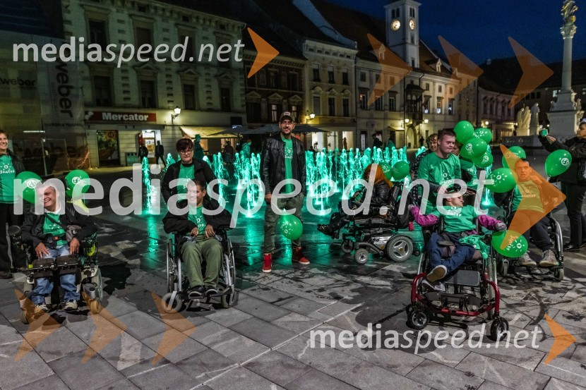 6pack Čukur in udeleženci.Zeleno obarvan Mariborski grad in fontana na Glavnem trgu ob svetovnem dnevu cerebralne paralize