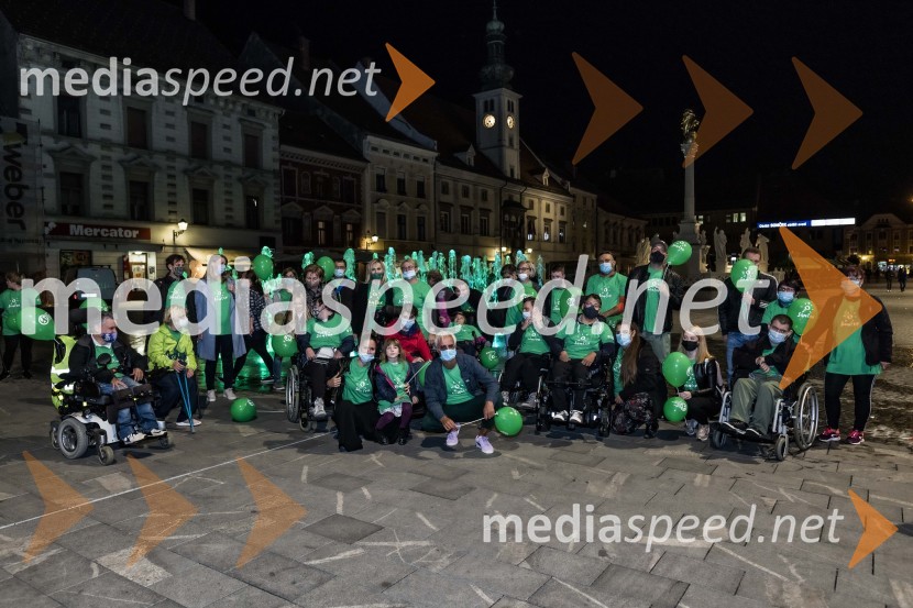 Zeleno obarvan Mariborski grad in fontana na Glavnem trgu ob svetovnem dnevu cerebralne paralize